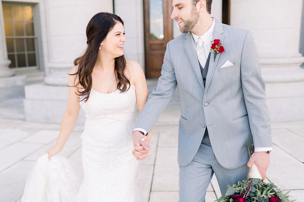 Arielle Peters Photography | Bride and groom holding hands on wedding day outside in downtown Madison, Wisconsin. 