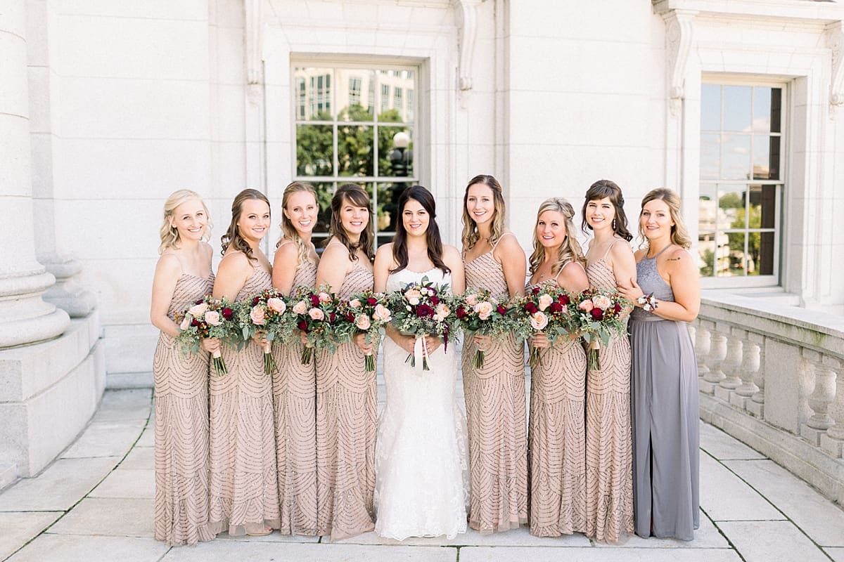 Arielle Peters Photography | Bride and bridesmaids lines up and smiling in downtown Madison, Wisconsin on wedding day.