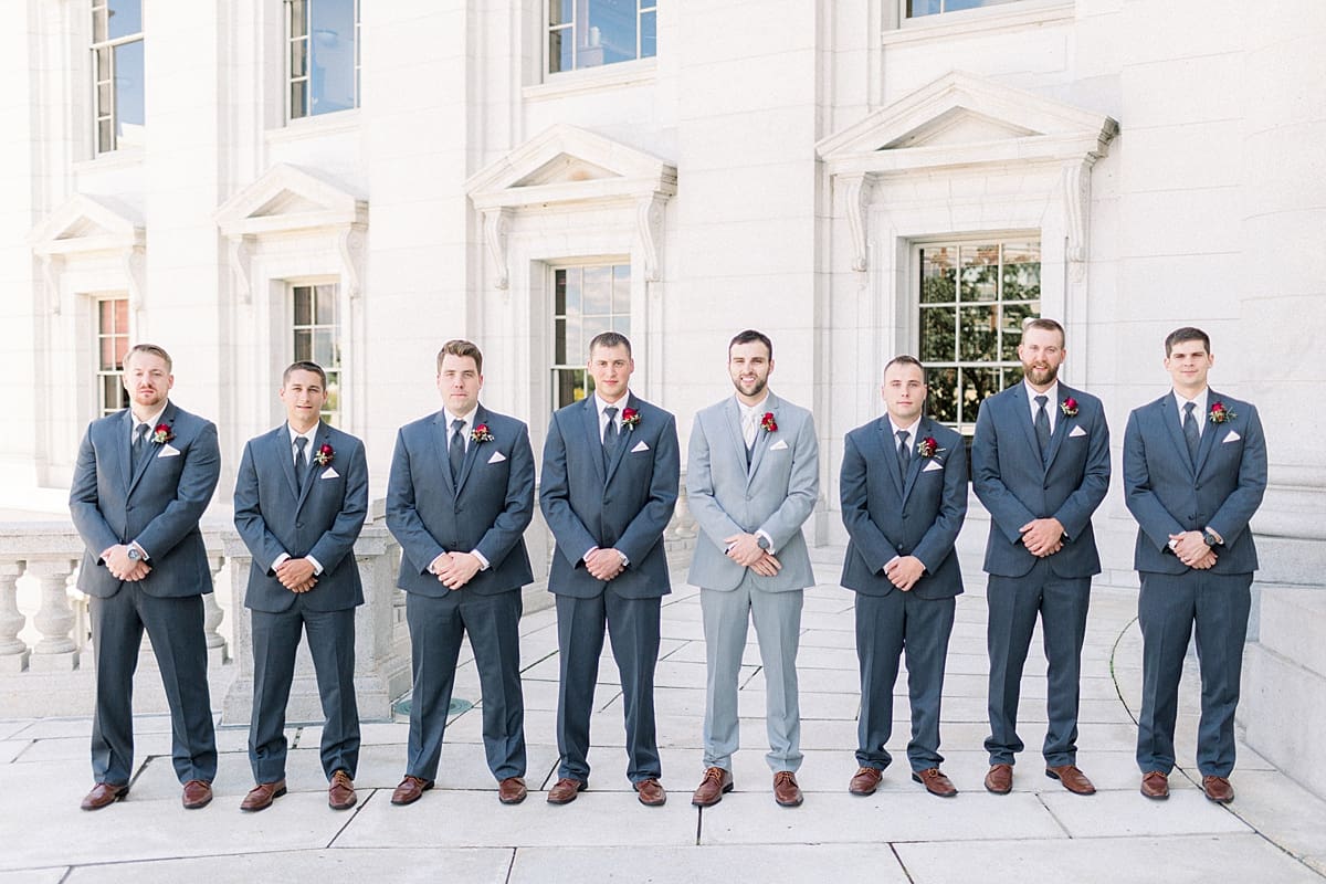 Arielle Peters Photography | Groom and groomsmen lined up and smiling on wedding day in downtown Madison, Wisconsin.