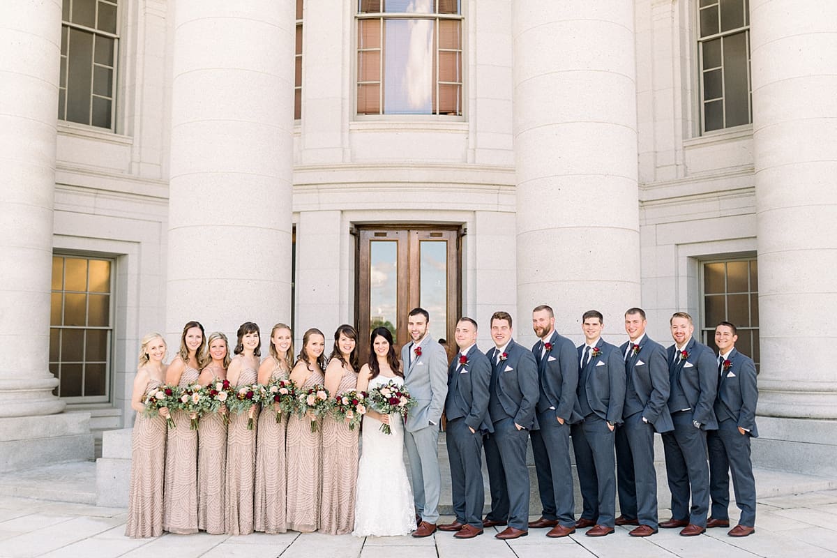 Arielle Peters Photography | Bride and groom smiling with wedding party outside Monona Terrace in Madison, Wisconsin on wedding day.