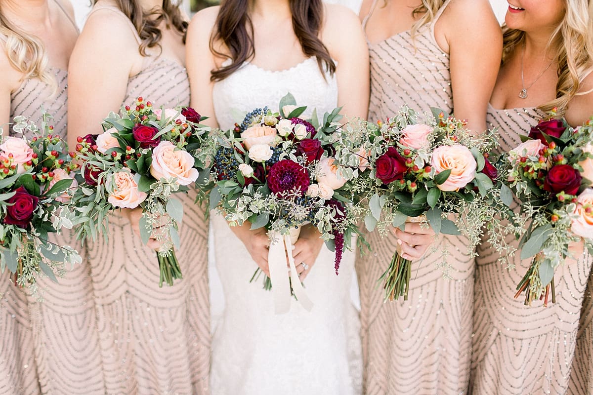Arielle Peters Photography |  Bride and bridesmaids holding bouquets in a line in Madison, Wisconsin on wedding day.