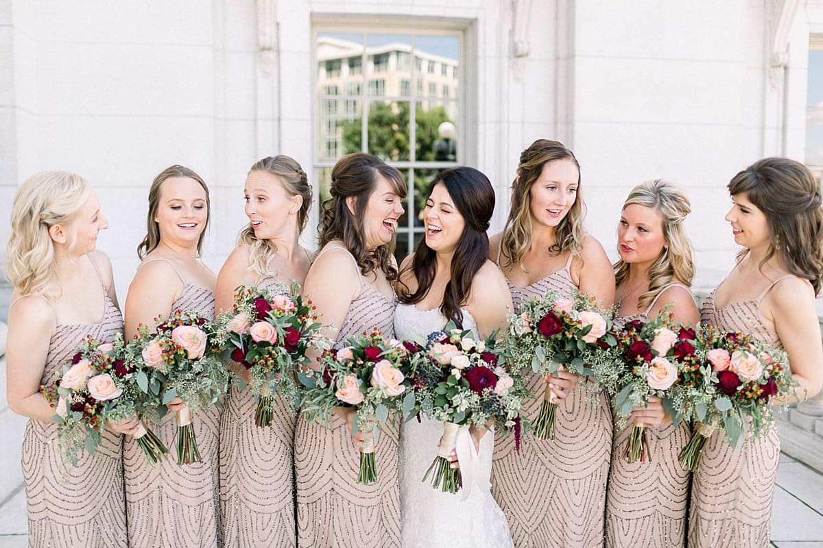 Arielle Peters Photography |  Bride and bridesmaids laughing holding bouquets outside Monona Terrace in Madison, Wisconsin on wedding day.