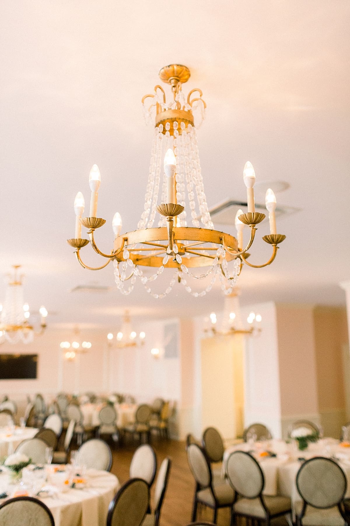 Arielle Peters Photography | Table settings and chandeliers inside the Madison Club in Madison, Wisconsin on wedding day.