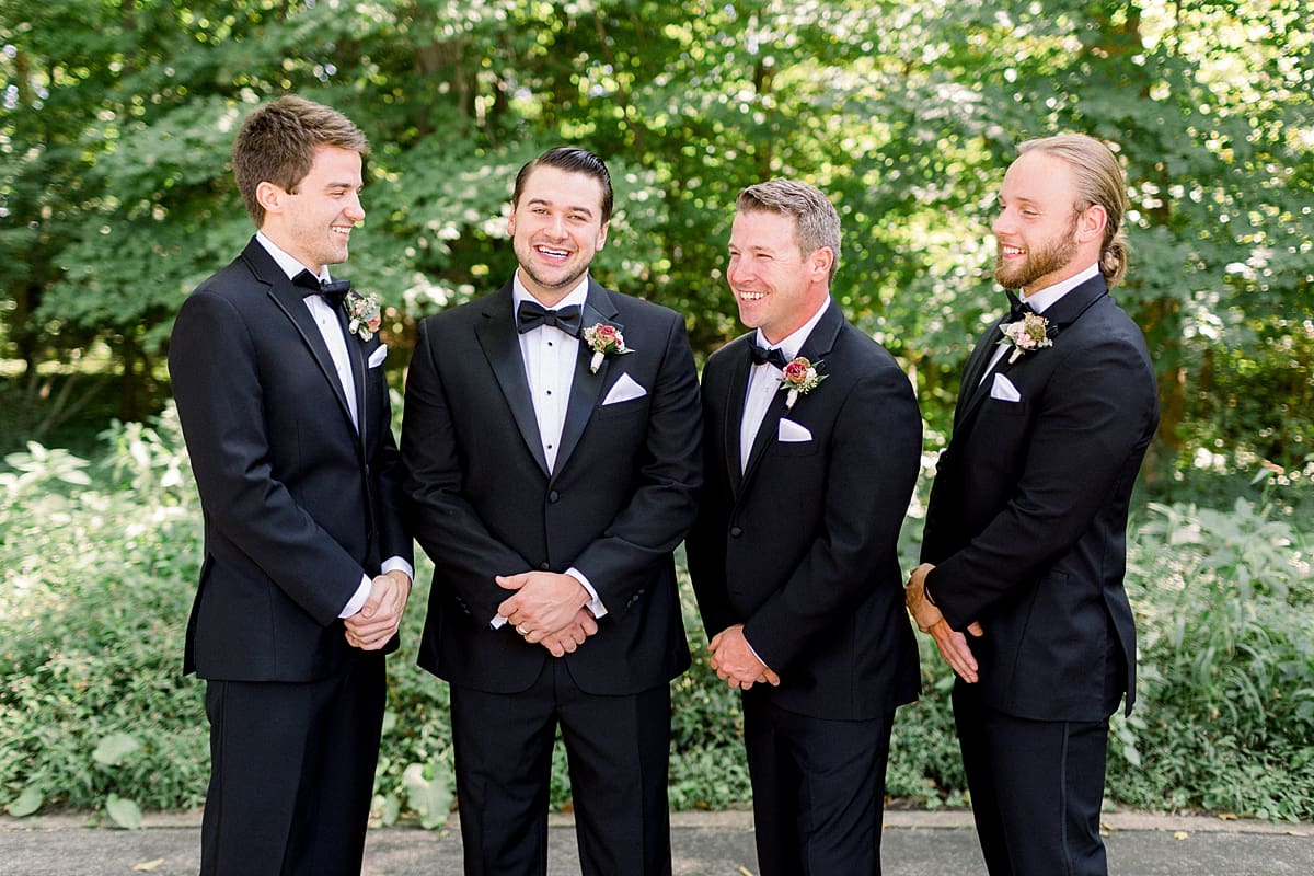 Arielle Peters Photography | Groom and groomsmen laughing together on wedding day at The Morris Estate in Niles, Michigan on wedding day. 