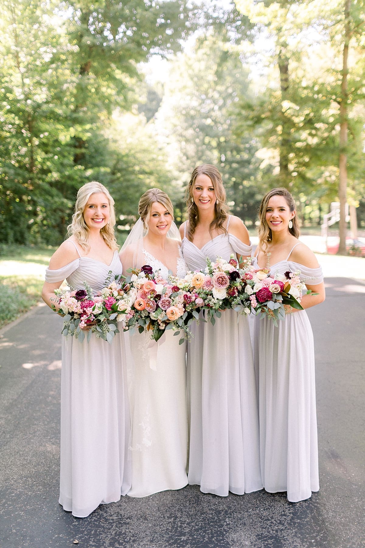 Arielle Peters Photography | Bride and bridesmaids smiling outside at The Morris Estate in Niles, Michigan on wedding day. 