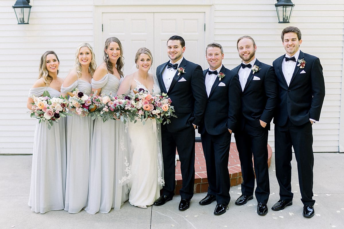Arielle Peters Photography | Bride and groom smiling with the wedding party outside of the church at The Morris Estate in Niles, Michigan on wedding day. 