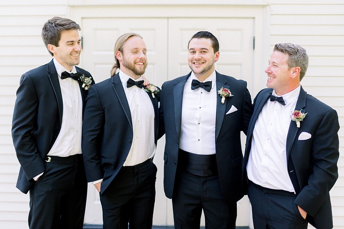 Arielle Peters Photography | Groom and groomsmen laughing outside the church at The Morris Estate in Niles, Michigan on wedding day. 
