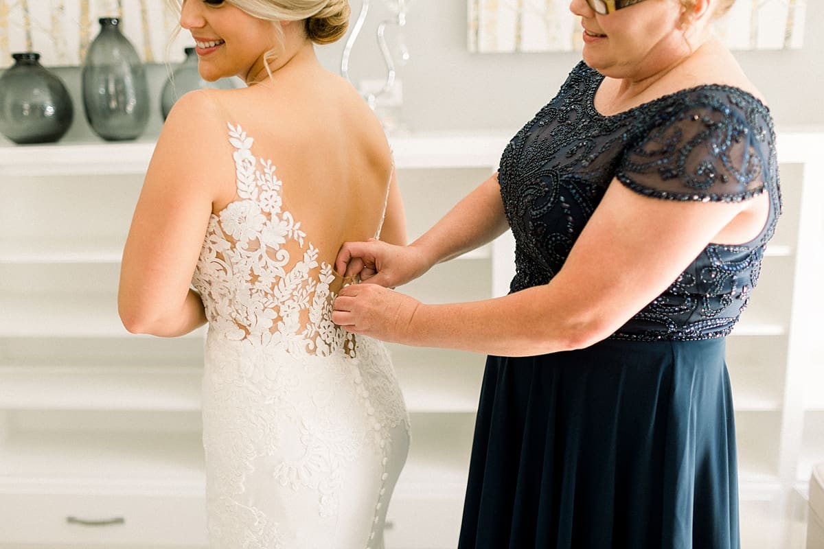 Arielle Peters Photography | Mother of the bride helping the bride put on her wedding dress at The Morris Estate in Niles, Michigan on wedding day. 