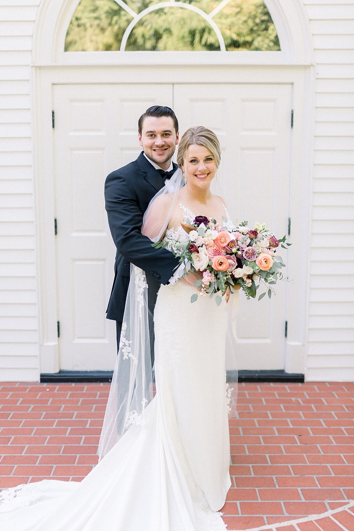 Arielle Peters Photography | Bride and groom smiling in each other's arms outside the church at The Morris Estate in Niles, Michigan on wedding day.  