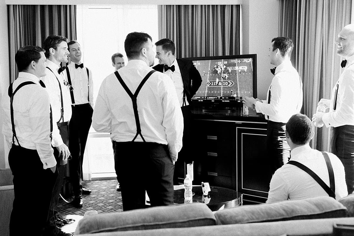 Arielle Peters Photography | Groom and groomsmen watching football in their tuxes on wedding day in Indianapolis