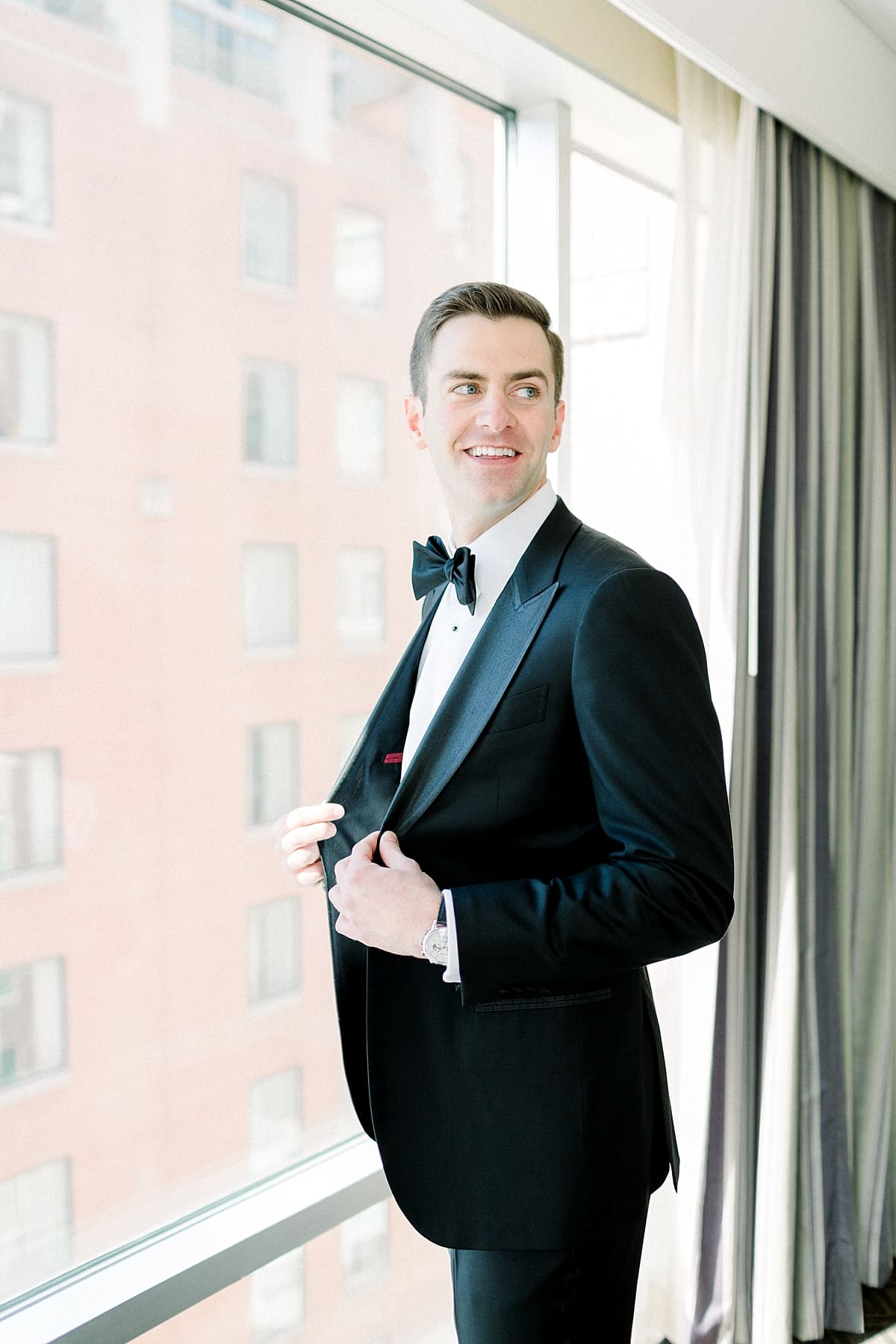 Arielle Peters Photography | Groom smiling next to window in his tux in Indianapolis on wedding day.