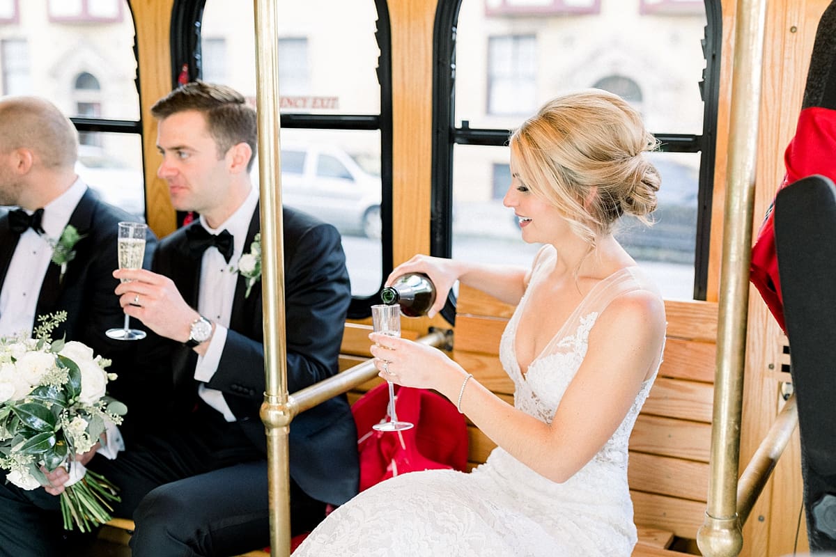 Arielle Peters Photography | Bride and groom pouring champagne inside Indy Trolley in Indianapolis on wedding day.