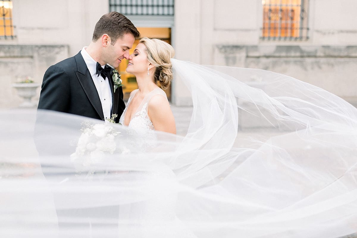 Arielle Peters Photography | Bride and groom kissing with veil flowing in the wind downtown Indianapolis on wedding day. 