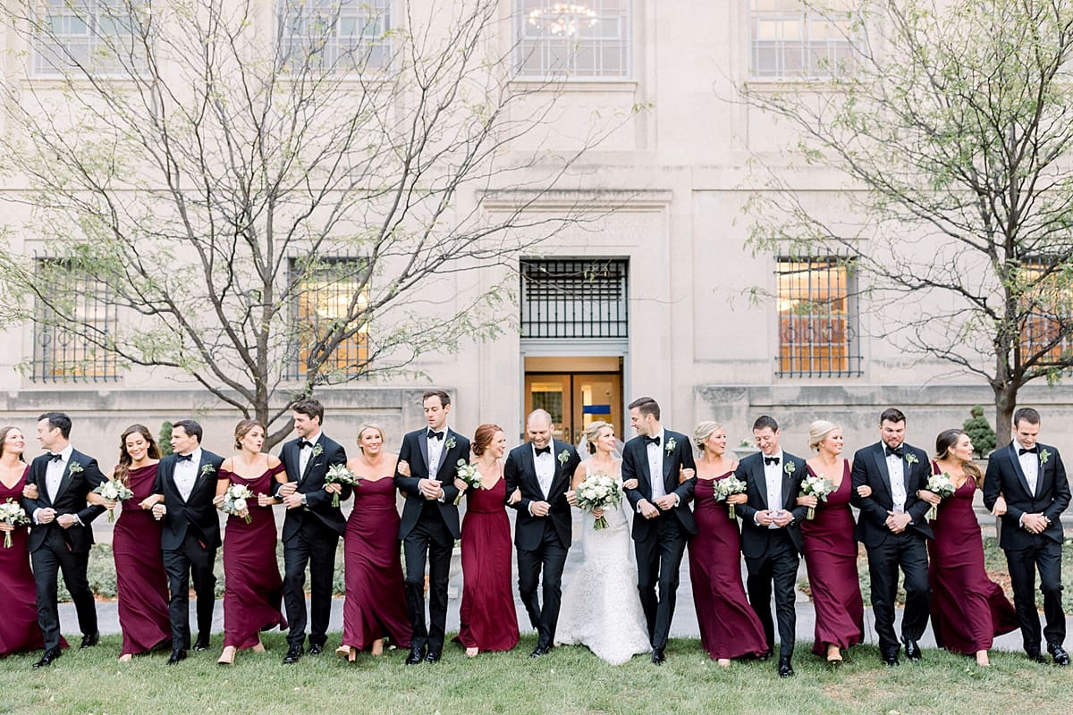 Arielle Peters Photography | Bride and groom with the wedding party linking arms in downtown Indianapolis on wedding day.