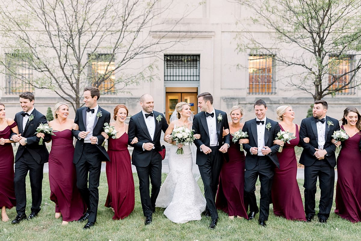 Arielle Peters Photography | Bride and groom walking with bridal party laughing downtown Indianapolis on wedding day.