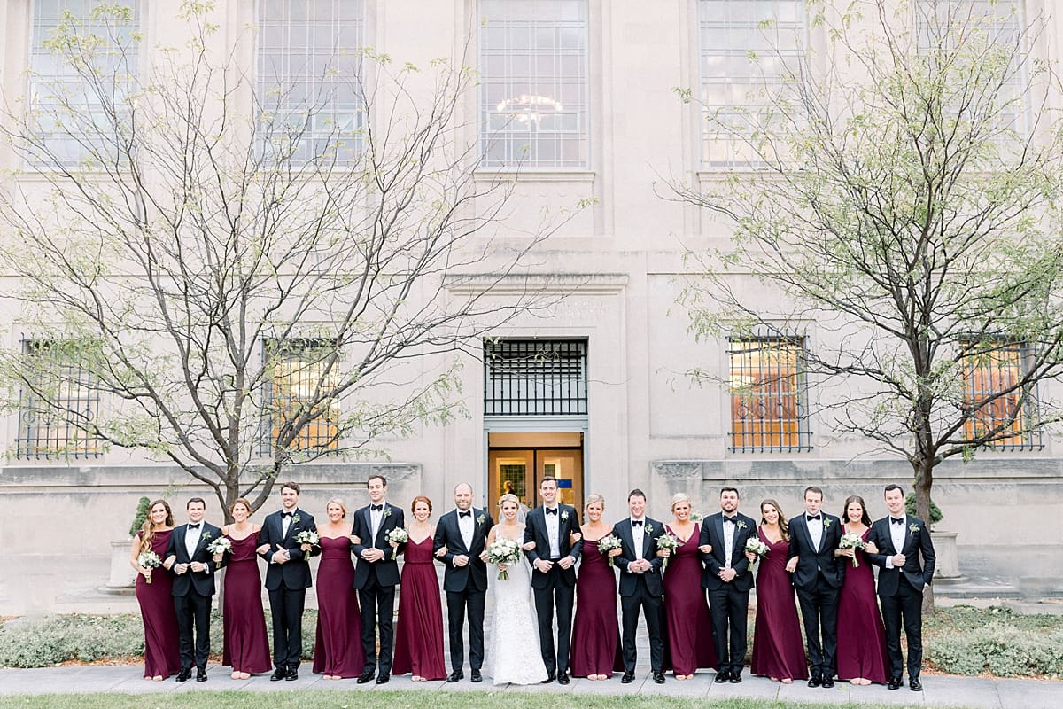 Arielle Peters Photography | Bride and groom and wedding party linking arms in downtown Indianapolis on wedding day.