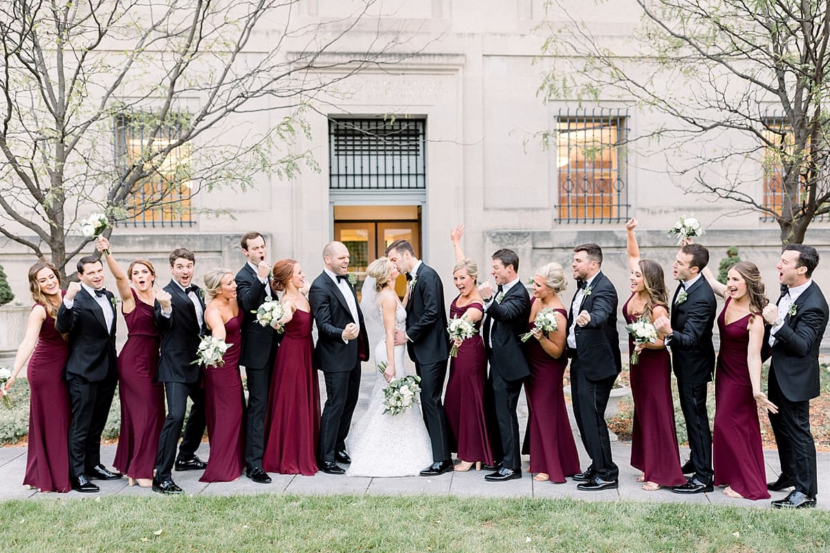 Arielle Peters Photography | Bride and groom kissing and wedding party cheering in downtown Indianapolis on wedding day.