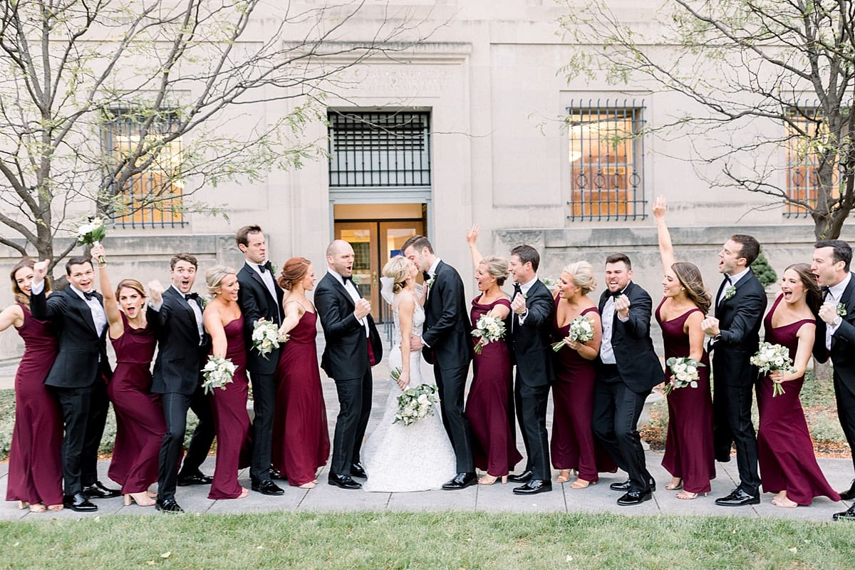 Arielle Peters Photography | Bride and groom kissing and wedding party cheering in Indianapolis on wedding day.