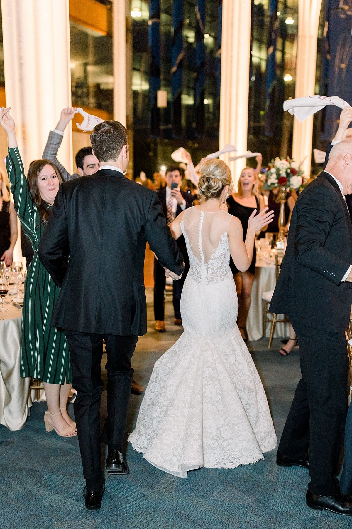 Arielle Peters Photography | Bride and groom entering wedding reception as guests cheer in Indy Public Library on wedding day.