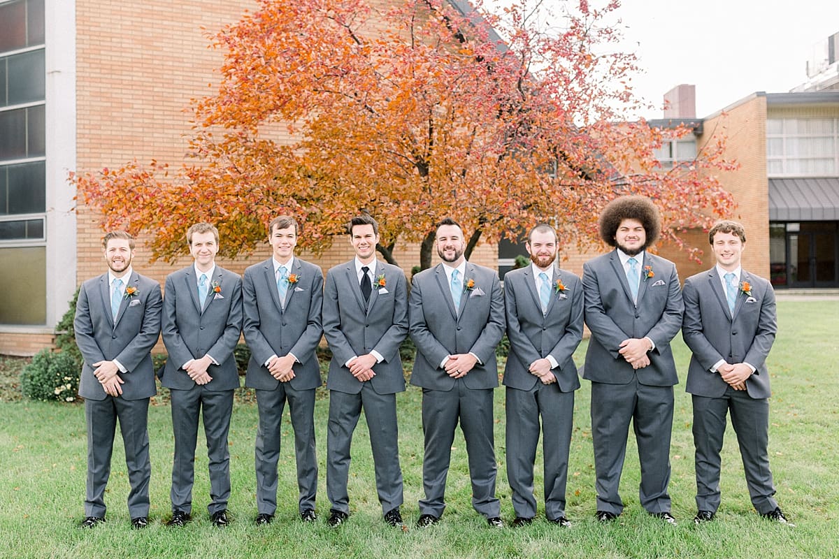 Arielle Peters Photography | Groom and groomsmen lined up smiling outside on fall wedding day.