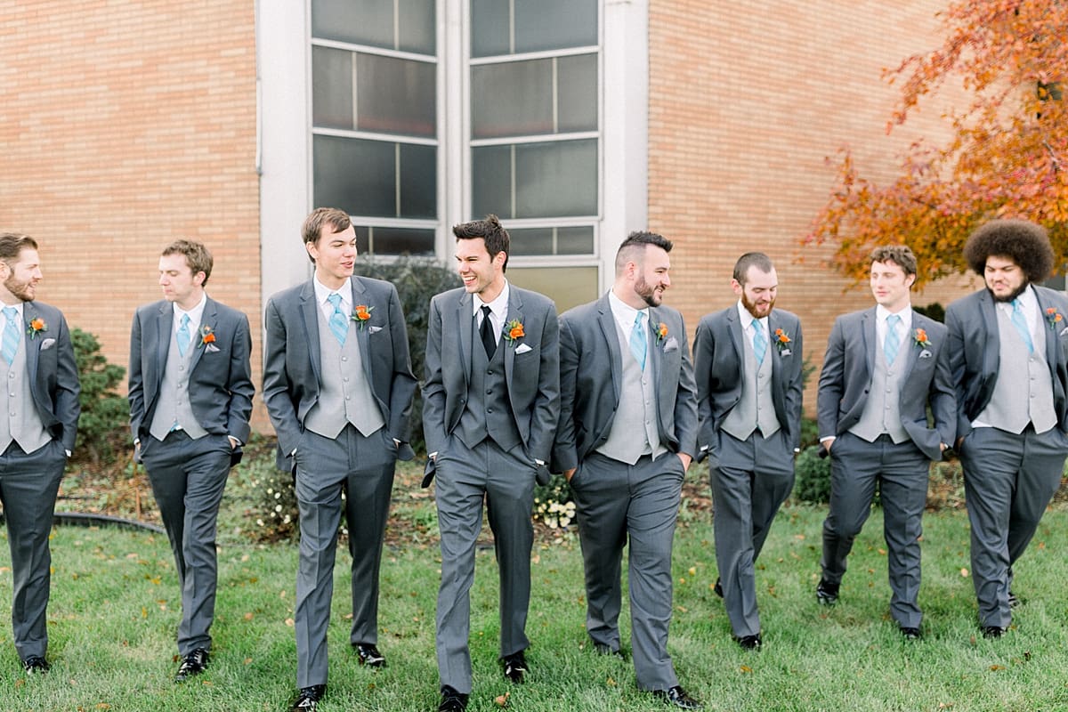 Arielle Peters Photography | Groom and groomsmen walking and smiling outside on fall wedding day.