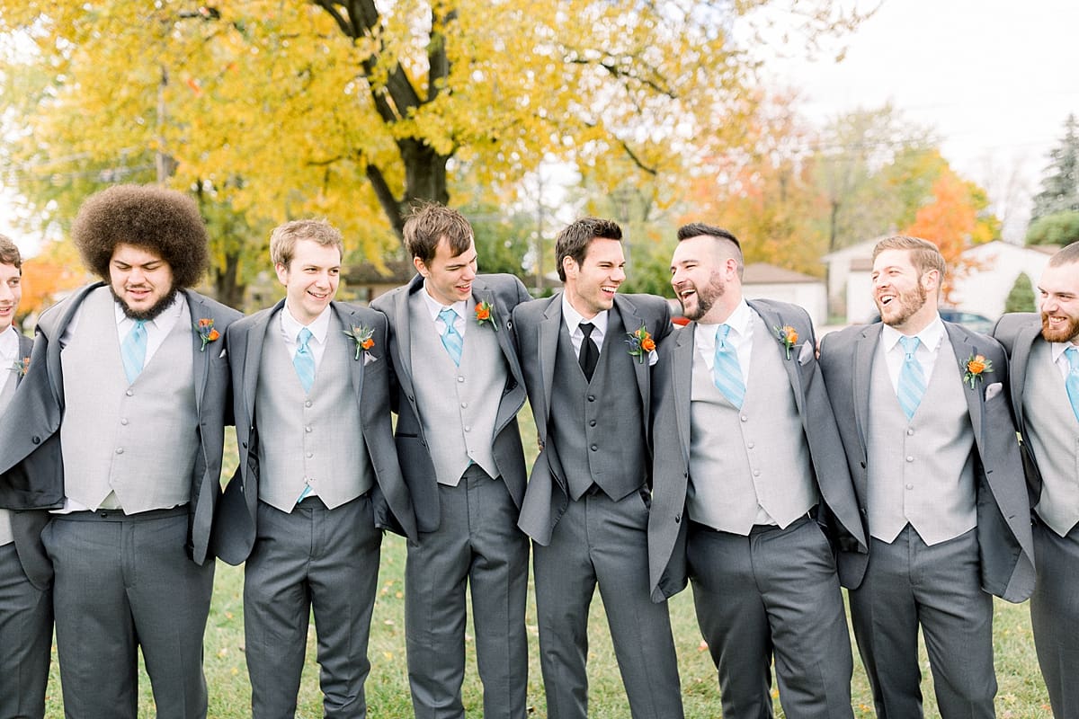Arielle Peters Photography | Groom and groomsmen lined up and laughing outside on fall wedding day.