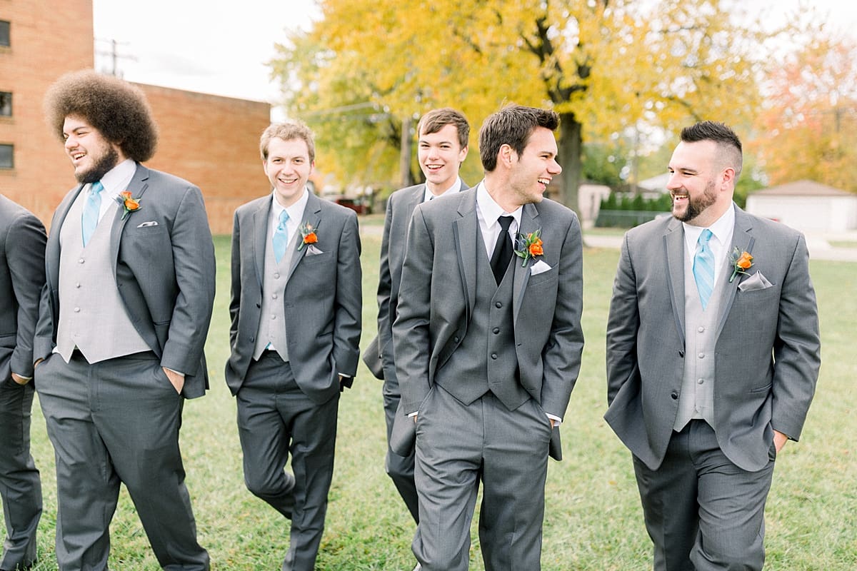 Arielle Peters Photography | Groom and groomsmen walking and laughing outside on fall wedding day.
