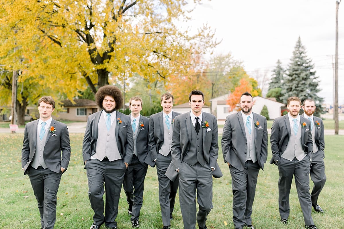 Arielle Peters Photography | Groom and groomsmen walking with serious faces outside on fall wedding day.