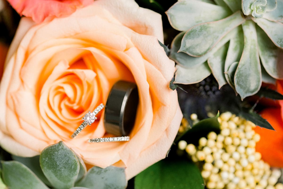 Arielle Peters Photography | Wedding rings in orange roses and succulents on fall wedding day.