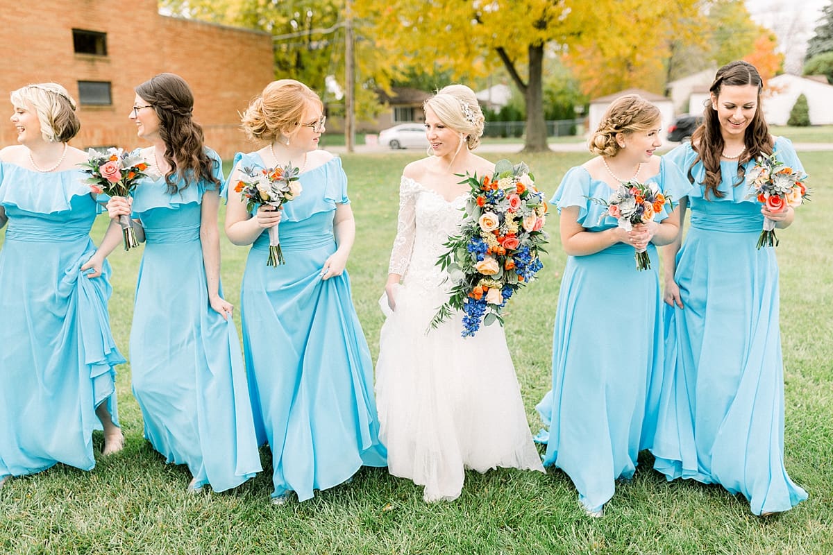 Arielle Peters Photography | Bride and bridesmaids walking with bouquets and smiling outside on fall wedding day.