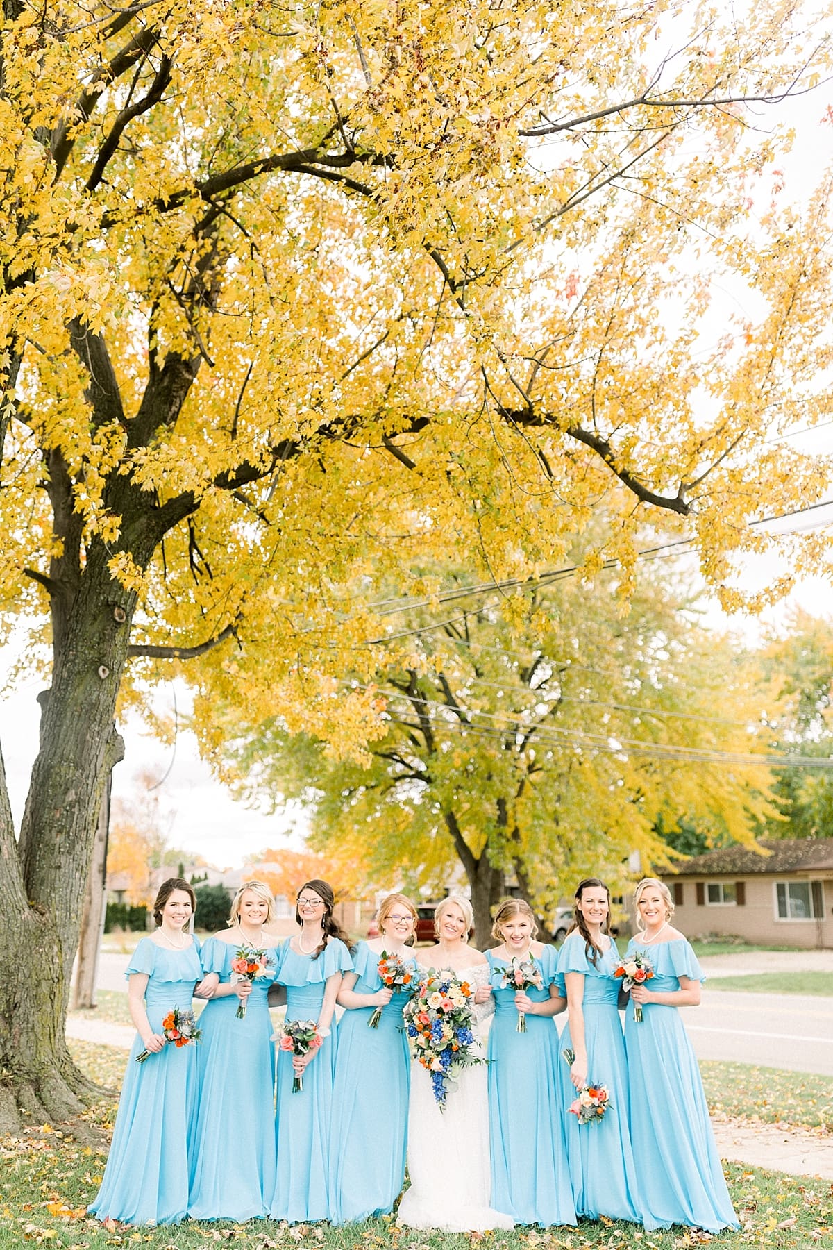 Arielle Peters Photography | Bride and bridesmaids smiling with bouquets outside on fall wedding day.