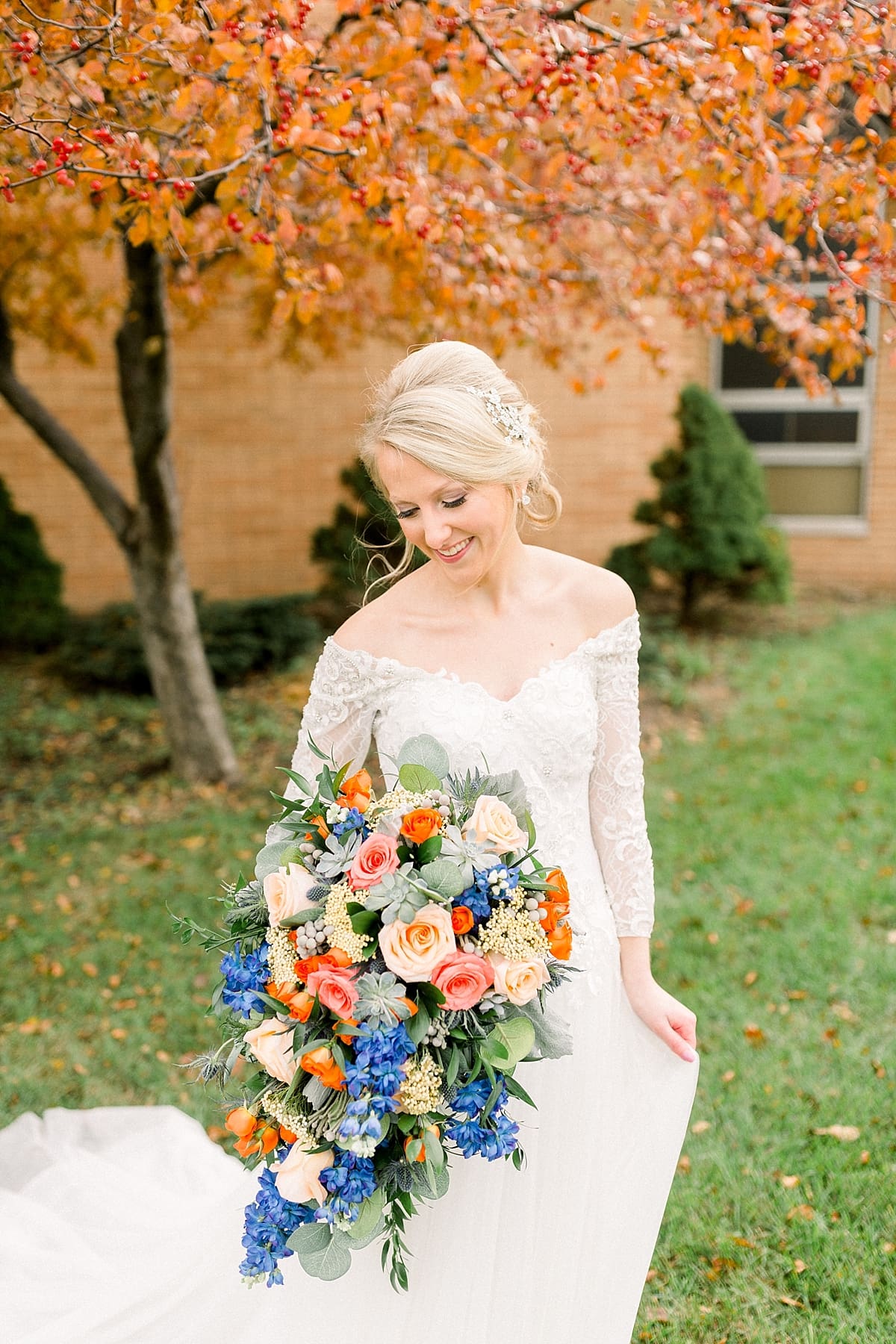 Arielle Peters Photography | Bride smiling with her bouquet outside on fall wedding day.