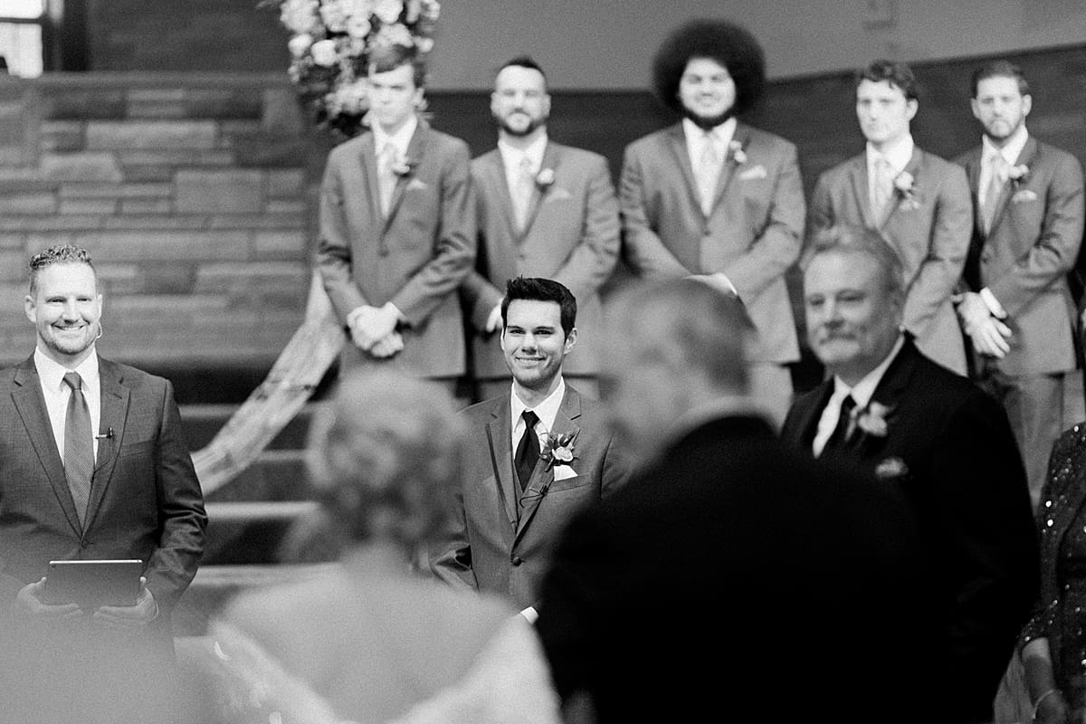 Arielle Peters Photography | Groom smiling at the bride as she walks down the aisle on their fall wedding day.
