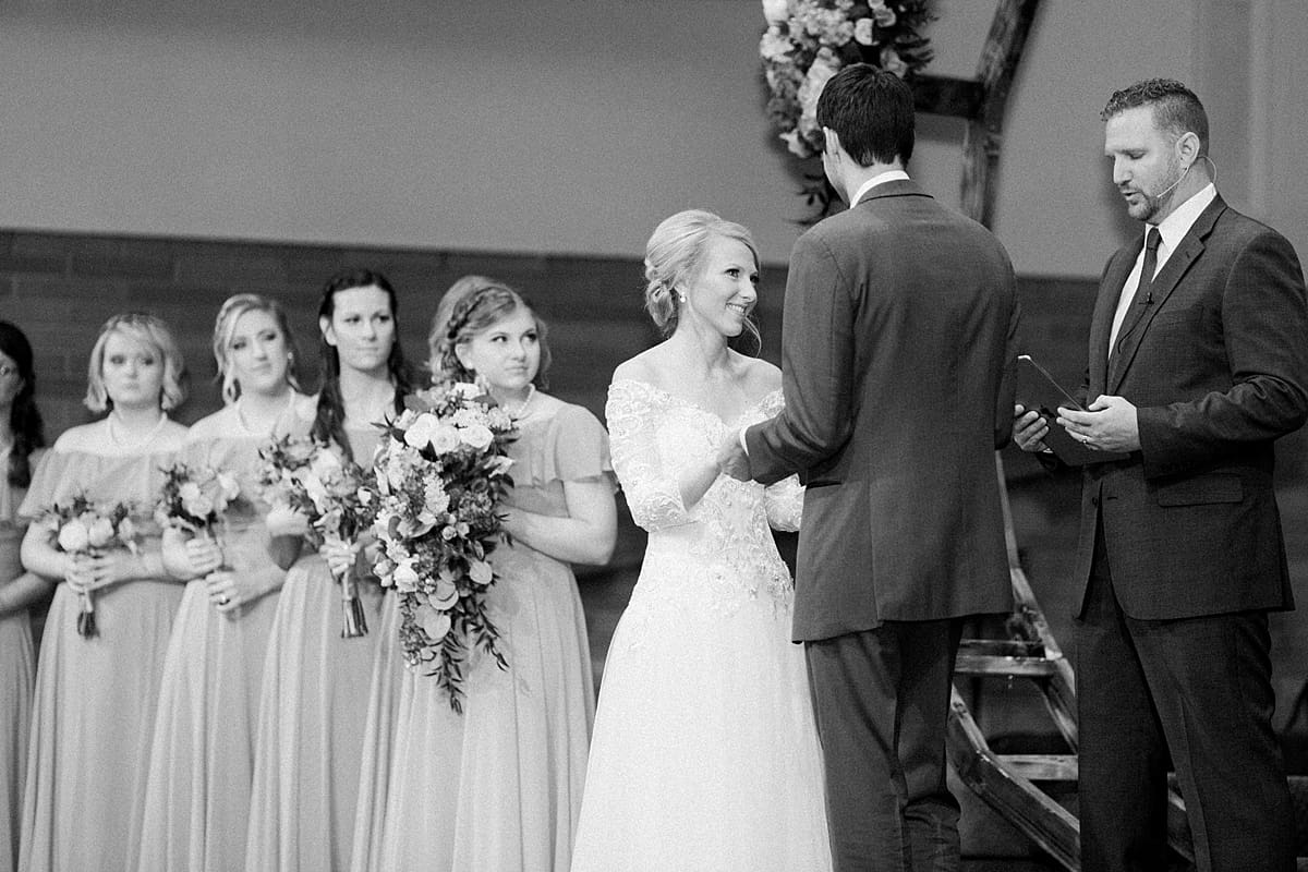 Arielle Peters Photography | Bride and groom smiling and holding hands at the alter on their fall wedding day.