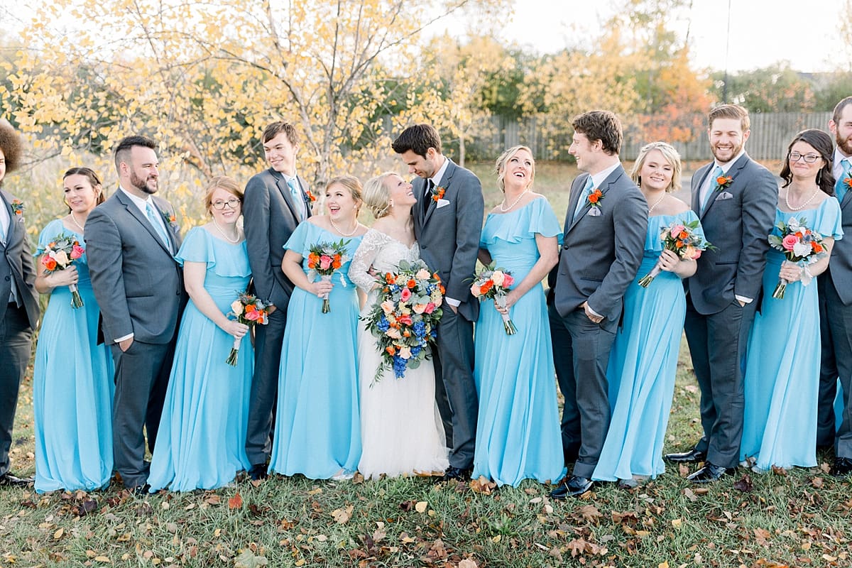 Arielle Peters Photography | Bride and groom smiling with wedding party outside on fall wedding day.