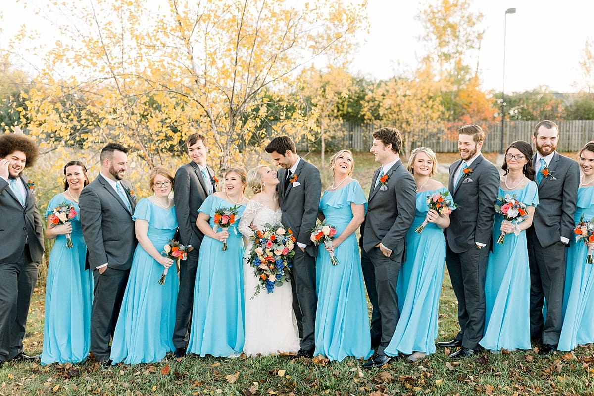Arielle Peters Photography | Bride and groom smiling with wedding party outside on fall wedding day.