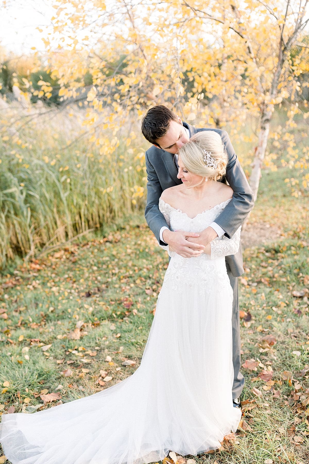 Arielle Peters Photography | Bride and groom kissing outside in a field on fall wedding day.
