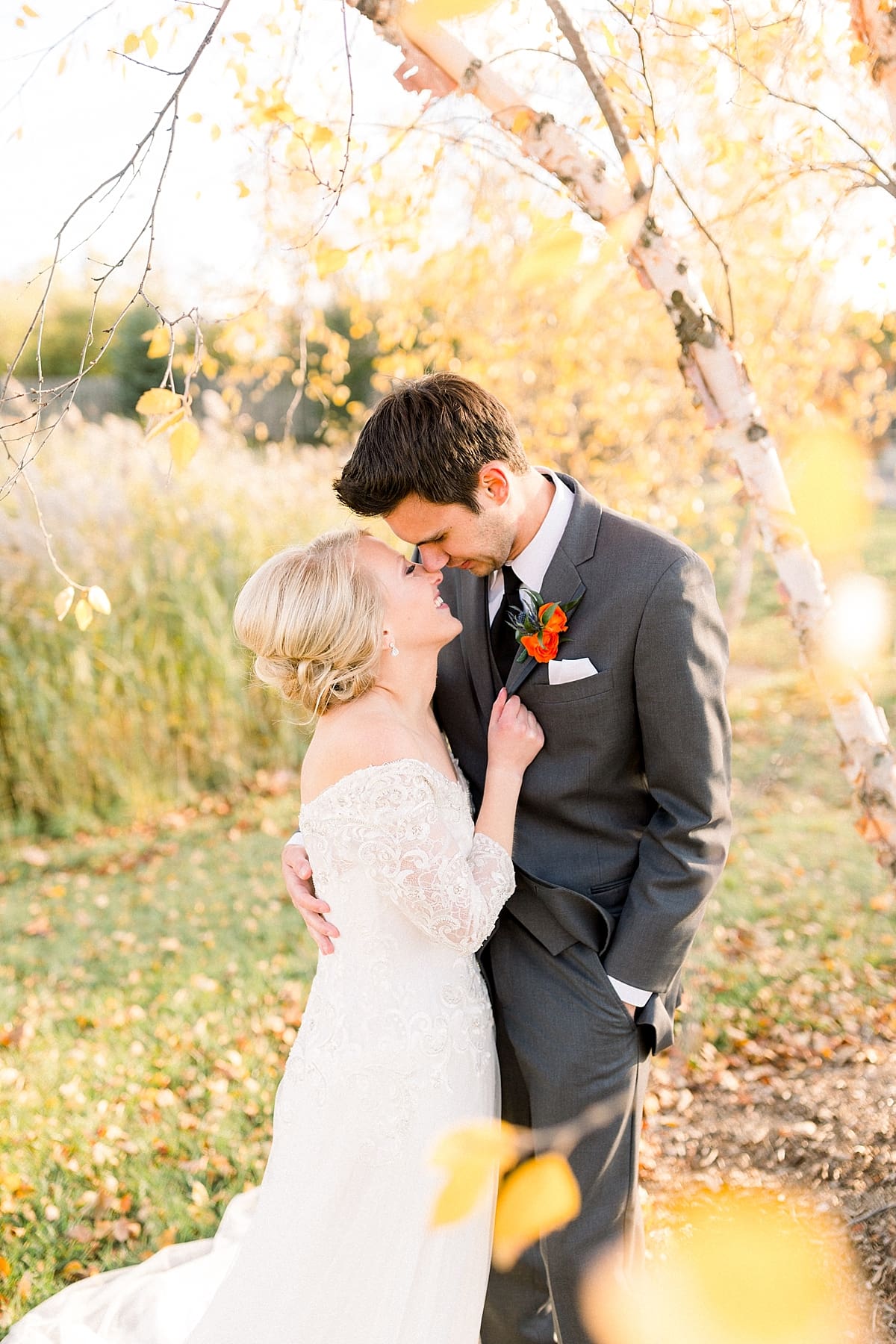 Arielle Peters Photography | Bride and groom smiling at each other outside under trees on fall wedding day.