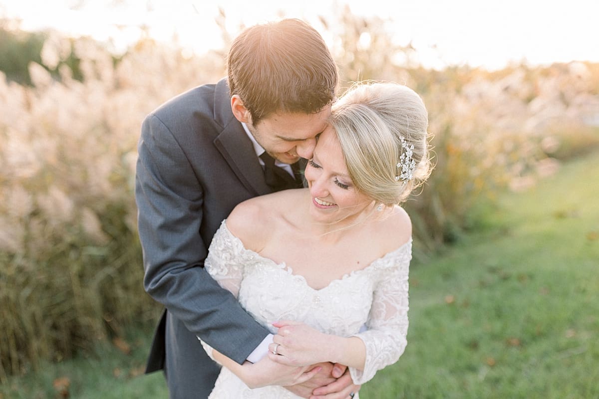 Arielle Peters Photography | Groom holding the bride in his arms outside in a field on fall wedding day.