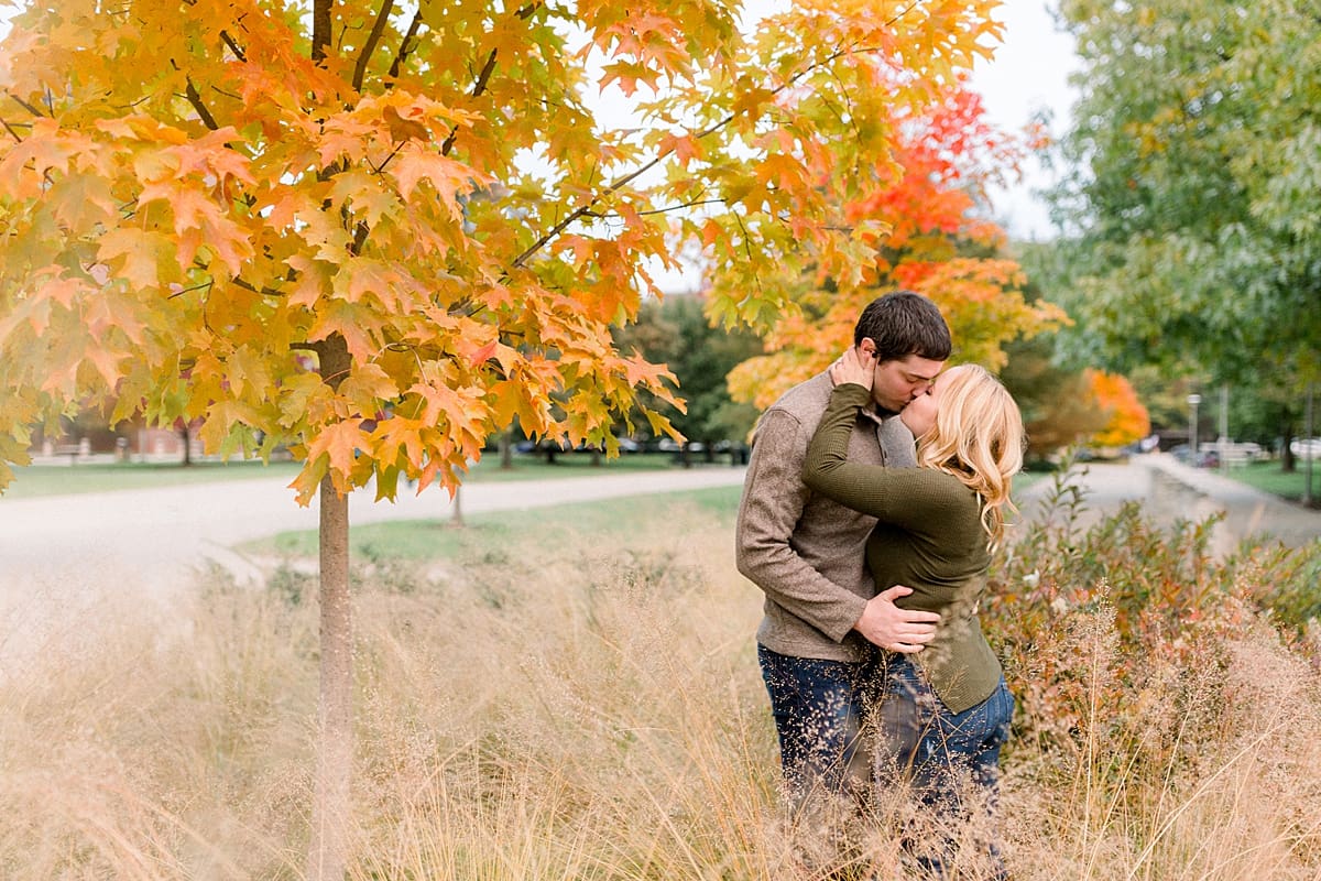 Arielle Peters Photography | Couple kissing and taking fall engagement photos in a field at Purdue University.