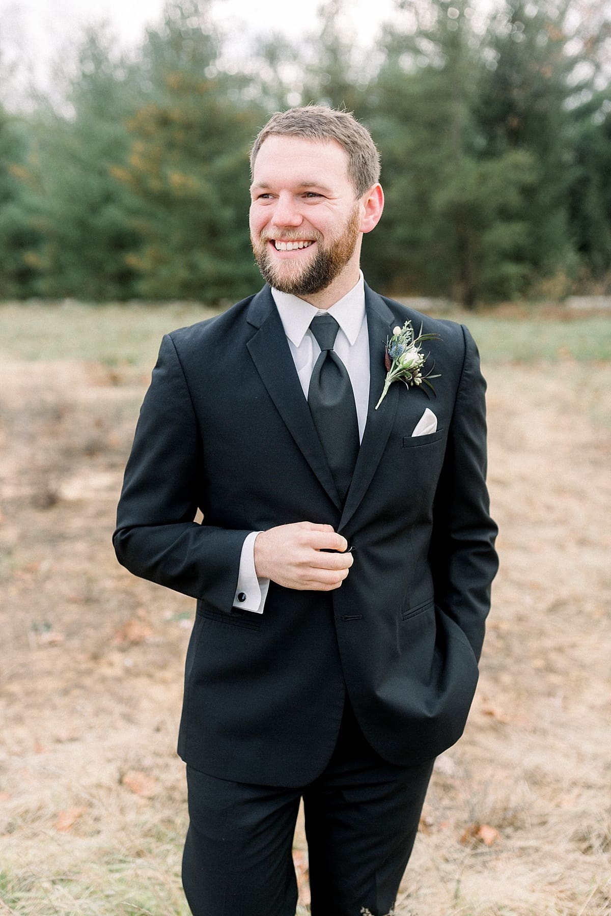 Arielle Peters Photography | Groom smiling in a field on wedding day.