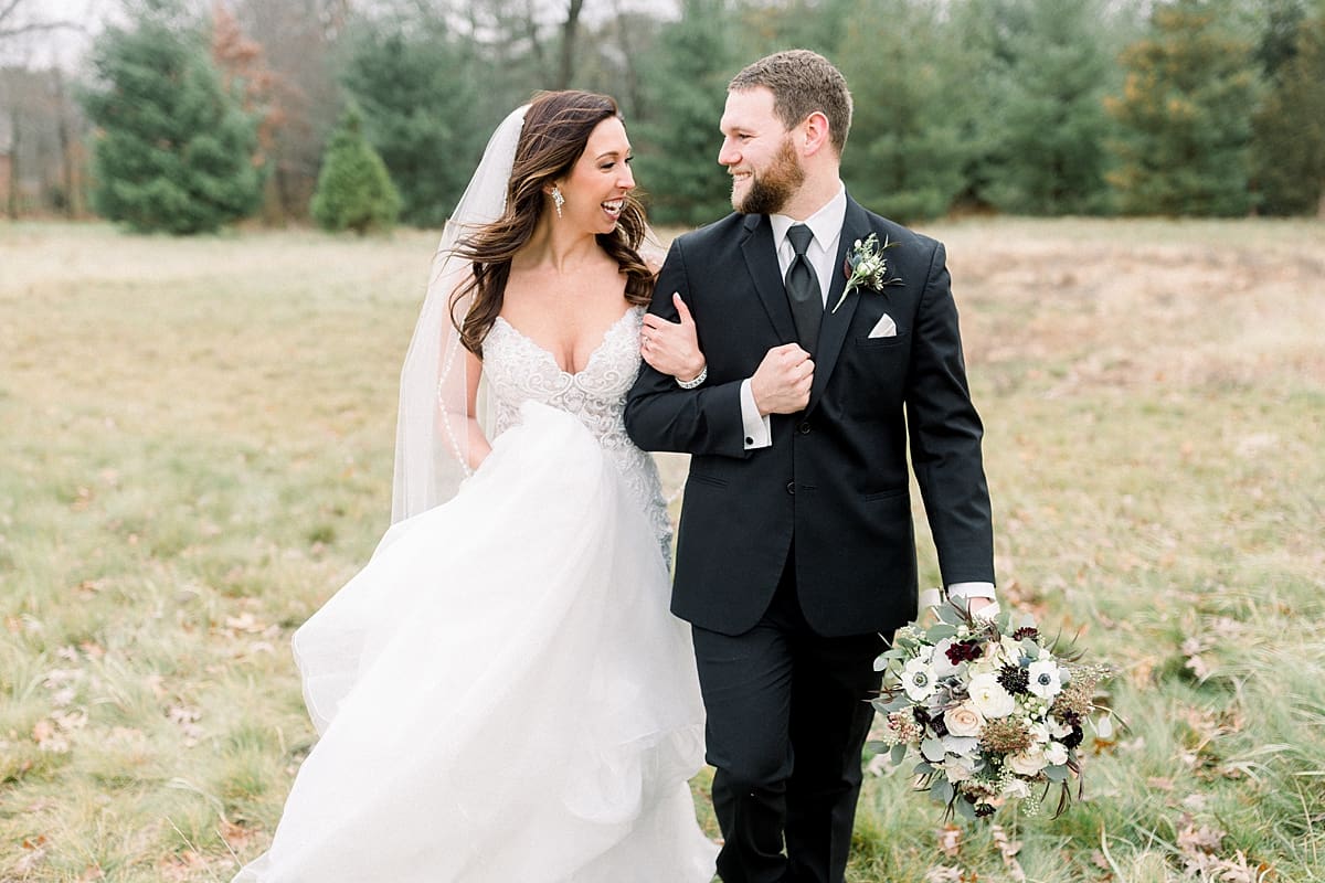 Arielle Peters Photography | Bride and Groom walking in a field laughing on their wedding day.