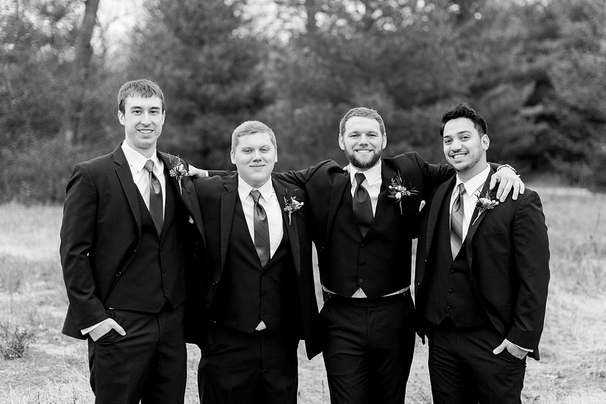 Arielle Peters Photography | Groom and groomsmen smiling in field on wedding day.