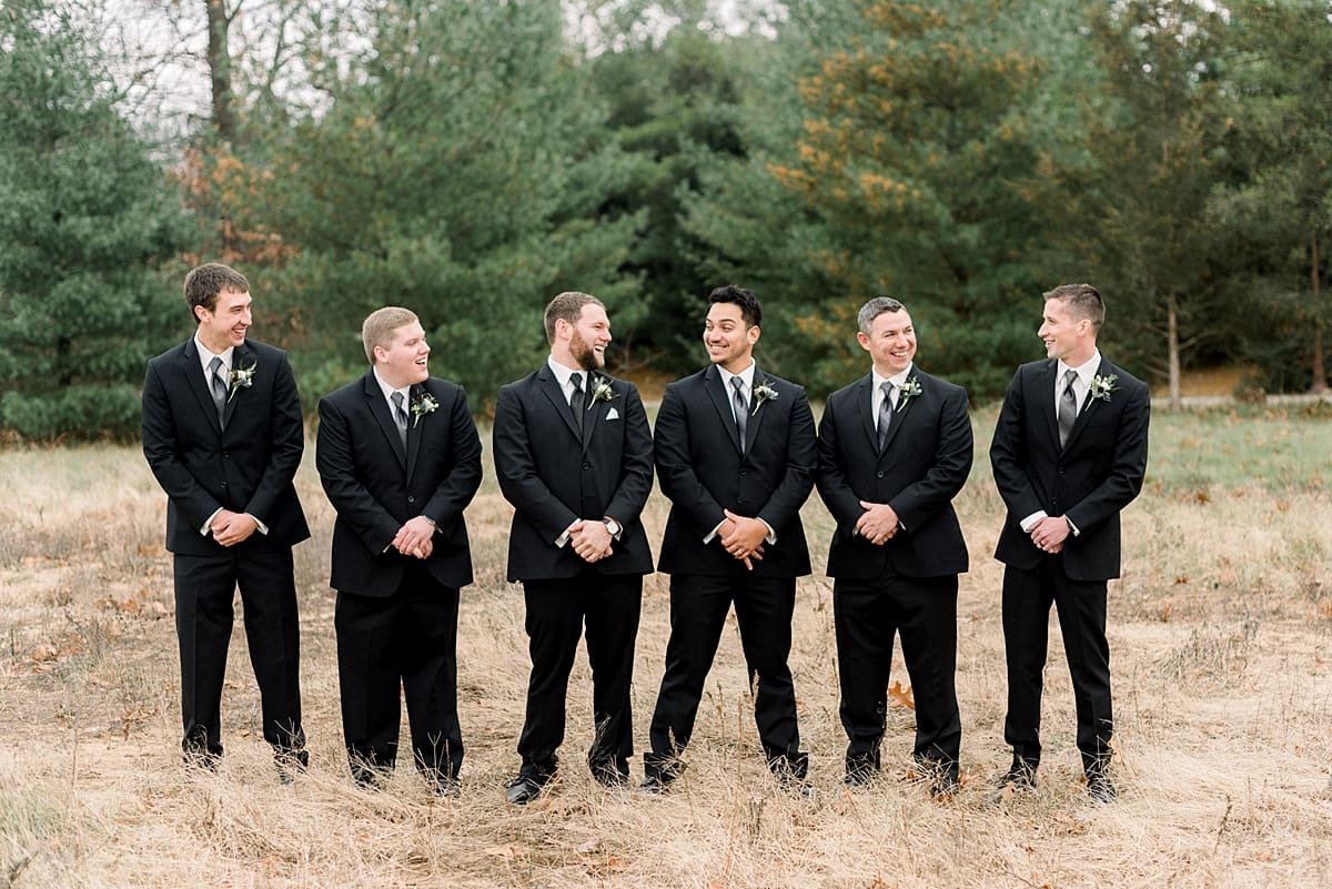 Arielle Peters Photography | Groom and groomsmen laughing in field on wedding day.