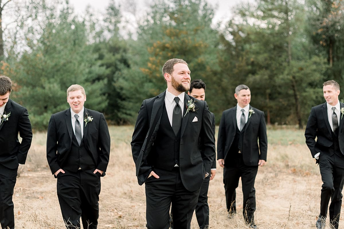 Arielle Peters Photography | Groom and groomsmen walking in field on wedding day.