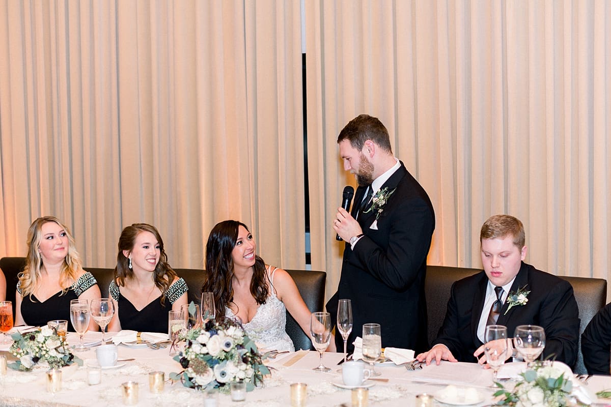 Arielle Peters Photography | Groom speaking to the bride at head table at wedding reception.