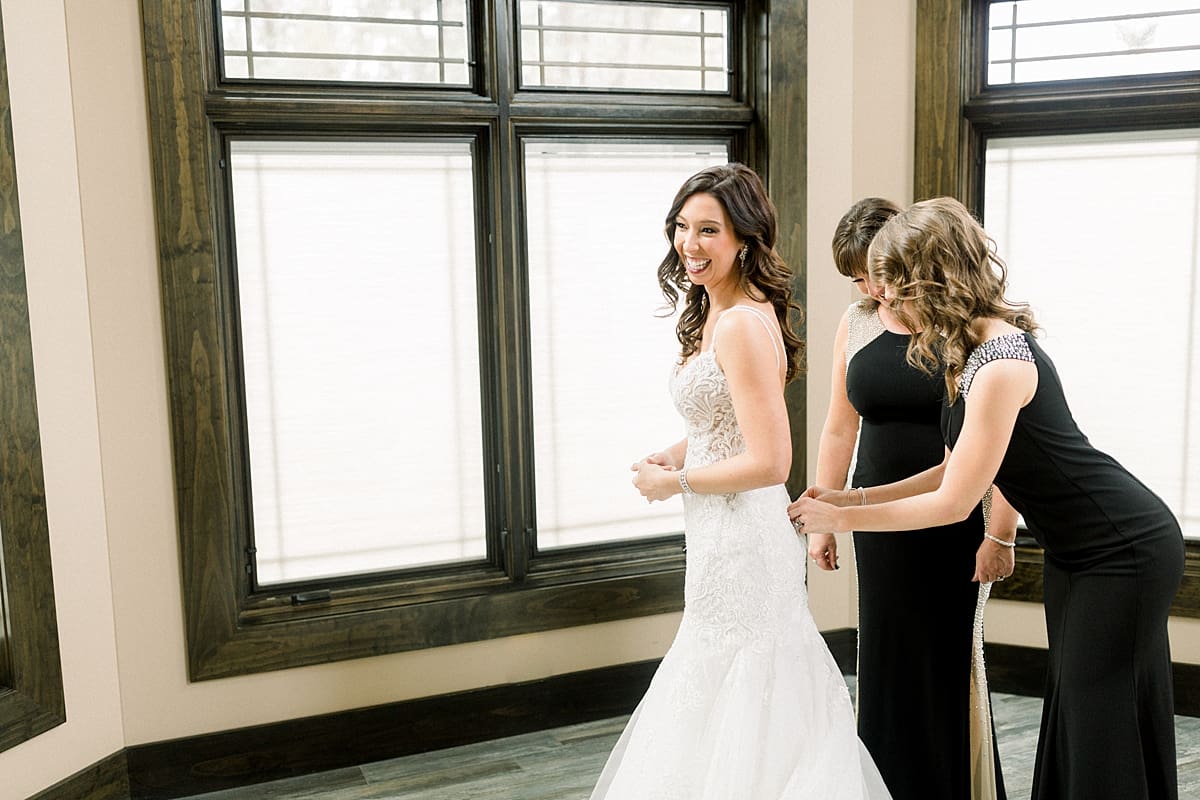 Arielle Peters Photography | Bride putting on her gown with bridesmaids.
