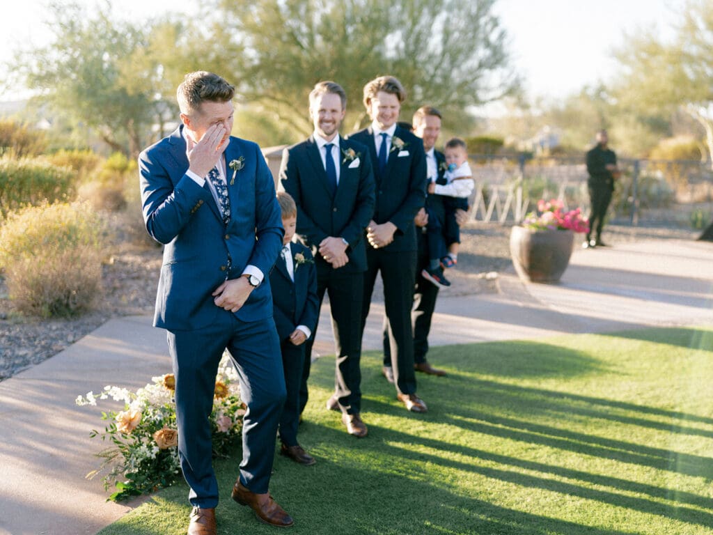 Groom getting emotional as he sees his soon to be wife walking down the aisle during their fall Blackstone Country Club wedding ceremony in Peoria