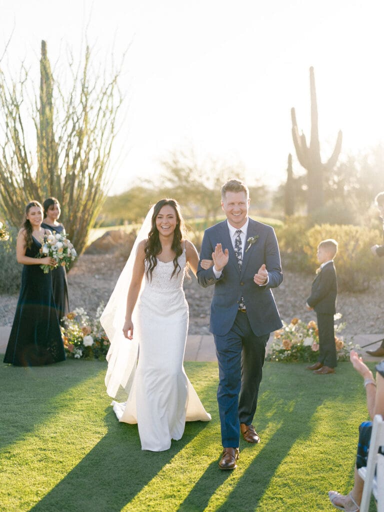 Bride and groom walking back down the aisle together after their Blackstone Country Club wedding ceremony in Peoria, Arizona.