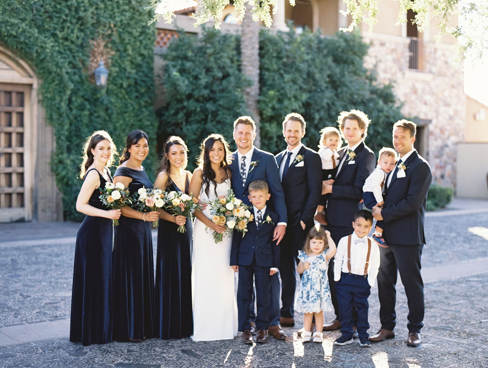 Bride and groom posing for photos with their wedding party at Blackstone Country Club in Peoria, Arizona
